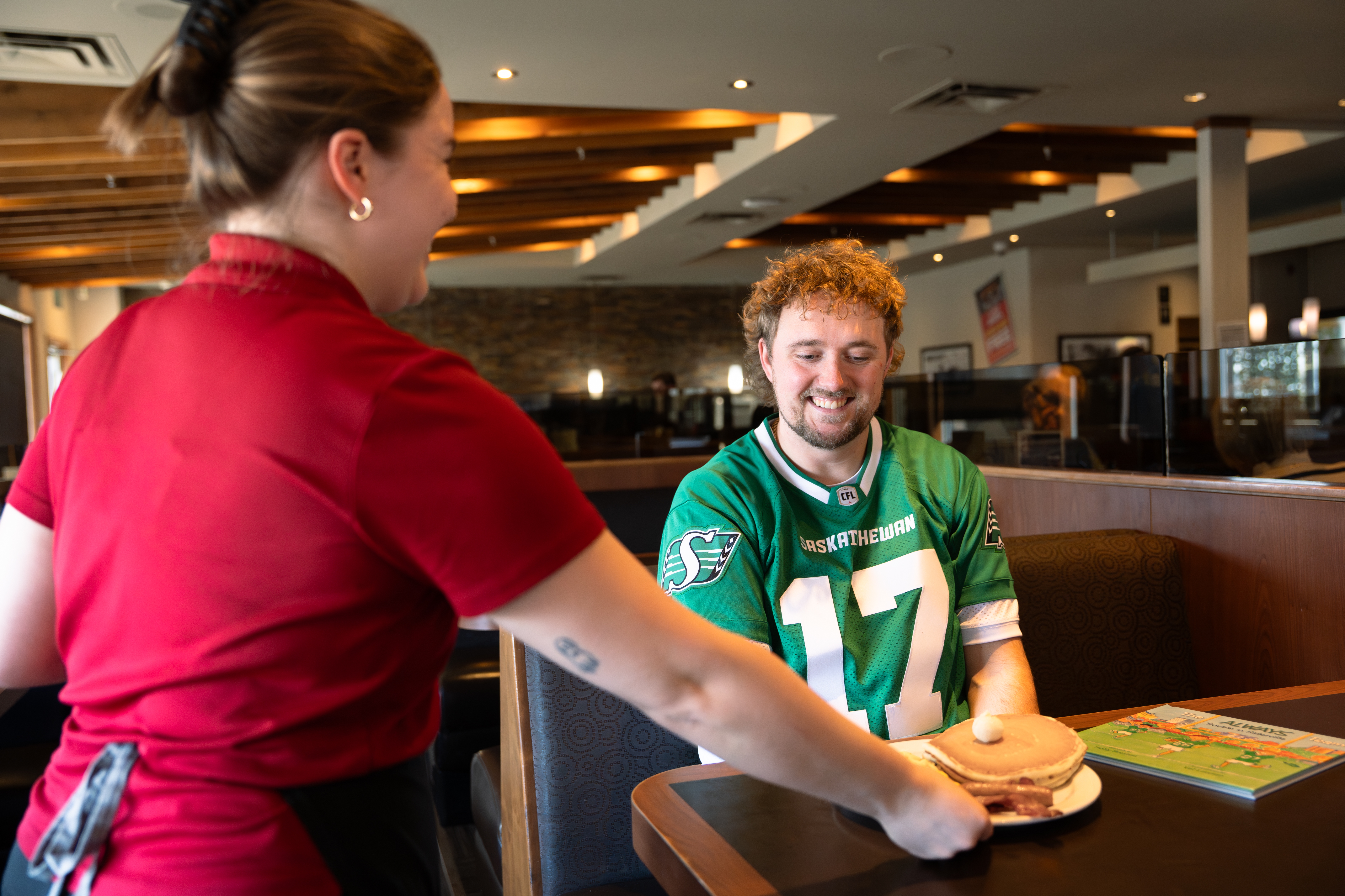 Denny’s Canada and Saskatchewan Roughrider Foundation waitress serves pancakes