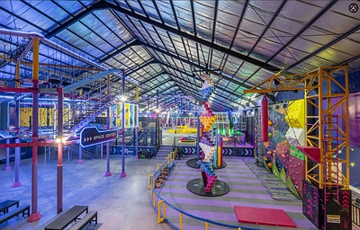 AeroXSpace Adventure Bali offers an all-weather indoor family experience with active play and shared challenges, featuring a variety of attractions including climbing walls and obstacle courses.