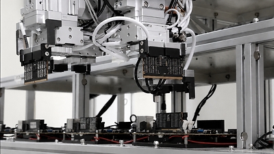 Gen Precision GTK-SPT1 automated DIMM final test system with robotic arm handling DDR4 and DDR5 memory modules for simultaneous testing.